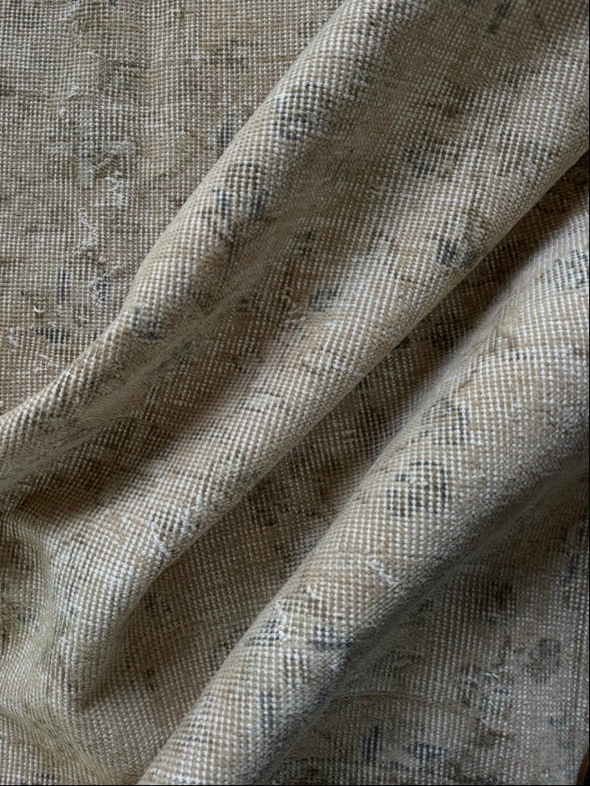 Close up of hand knotted vintage rug in soft muted neutral colors